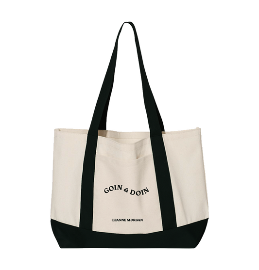 A canvas tote bag with black trim and handles, featuring the text 'GOIN' & DOIN" on the front pocket.